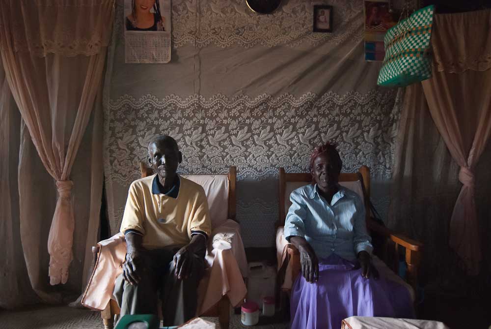 Pastor Awino and his wife, elders within the St. Luke's community, at their home. Most villagers in Miwani live in simple mud-walled homes with two rooms without amenities or electricy.  