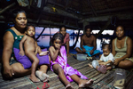 Tebunginako Village, Abaiand Island. A family relax in their common living area. The high tide now separates them from the rest of the village. They say this is a reletively new phenomenon that has gotten progressively worse over the last 15 years.
