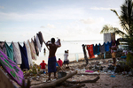 A man hangs out his laundry, Bairiki Village, Tarawa Island, Kiribati. This is one of the most high density slum areas in Kiribati.