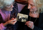 Rose Soghoian, left, and her sister, Florence Soghoian, hold their mother's 1914 family photograph. Their mother, Grace K. Soghoian, third from left, was 6 in 1914. After the massacre of the Armenians by the Turks, only she and her mother, second from left, survived.