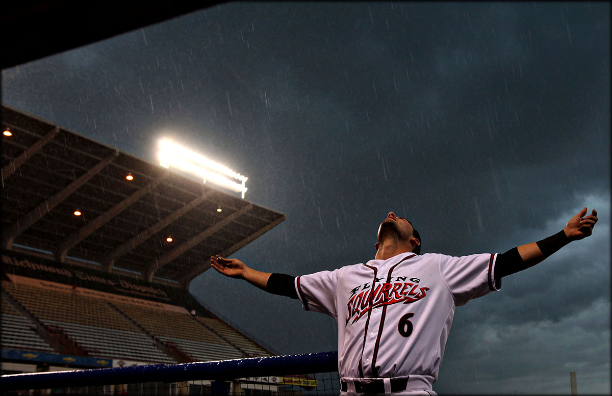 Richmond Flying Squirrels' Andrew Susac opens arms to feel rain as a severe thunderstorm approaches to area and stopped the baseball game. 