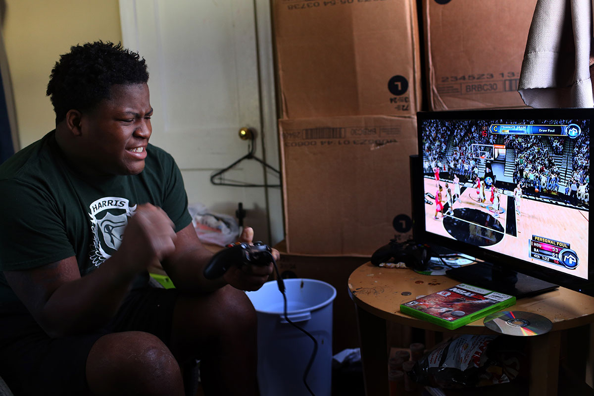 Edward plays Xbox basketball game at his home in Richmond. Edward likes to play the game as this is only way he can feel like playing sports, which he loves. His mom, Lawanda Booker, said that he used to be very outgoing and athletic kid but his medical issues keep him inside. 