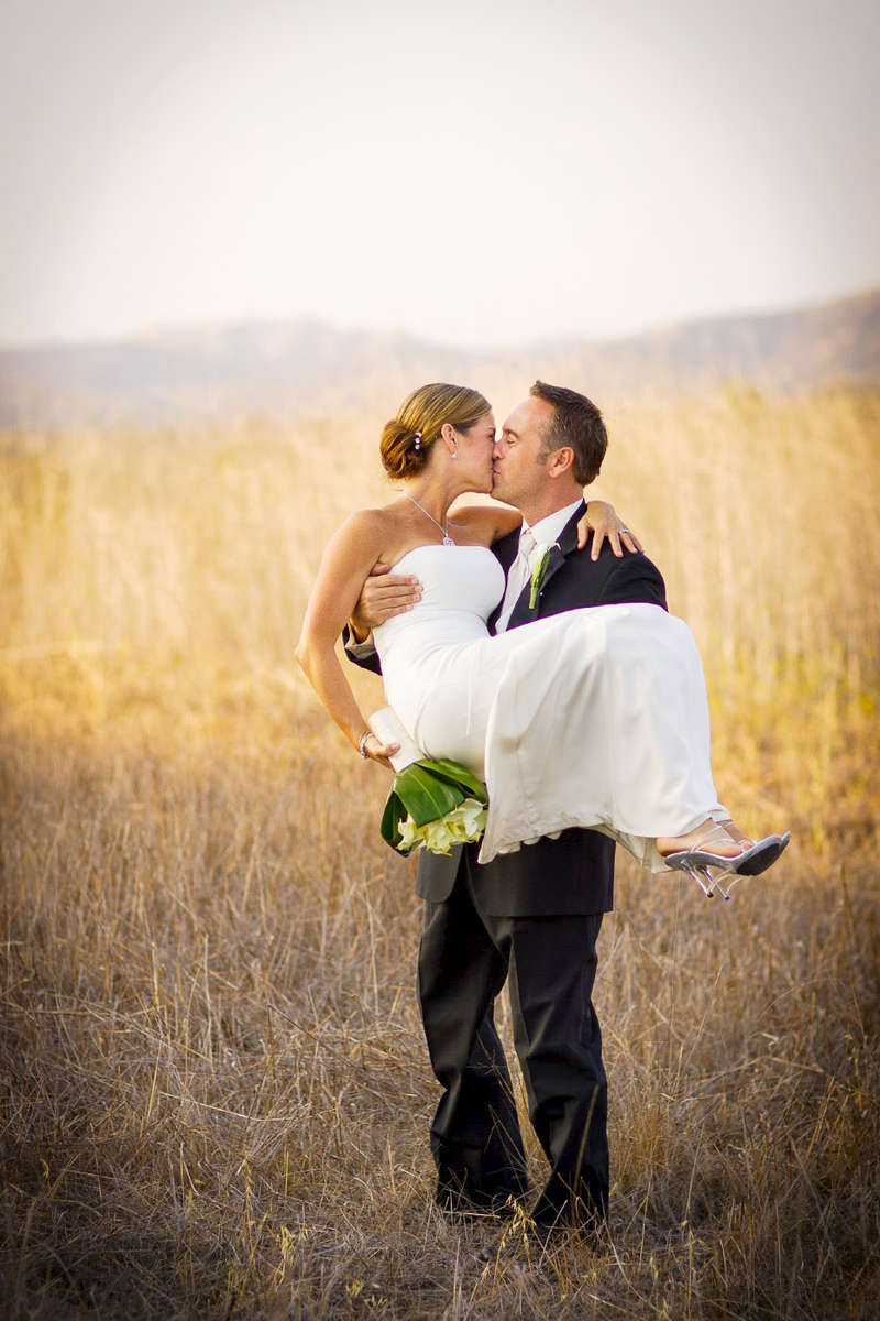 open-field-of-weeds-and-dry-brush-with-bride-and-groom
