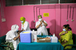 Medical workers distribute doses of Pfizer Covid-19 vaccines in Dhaka, Bangladesh. Bangladesh enacted a nationwide lockdown on July 1st in an effort to contain a third wave of Covid, as cases have surged, fueled by the Delta variant first detected in neighboring India.  