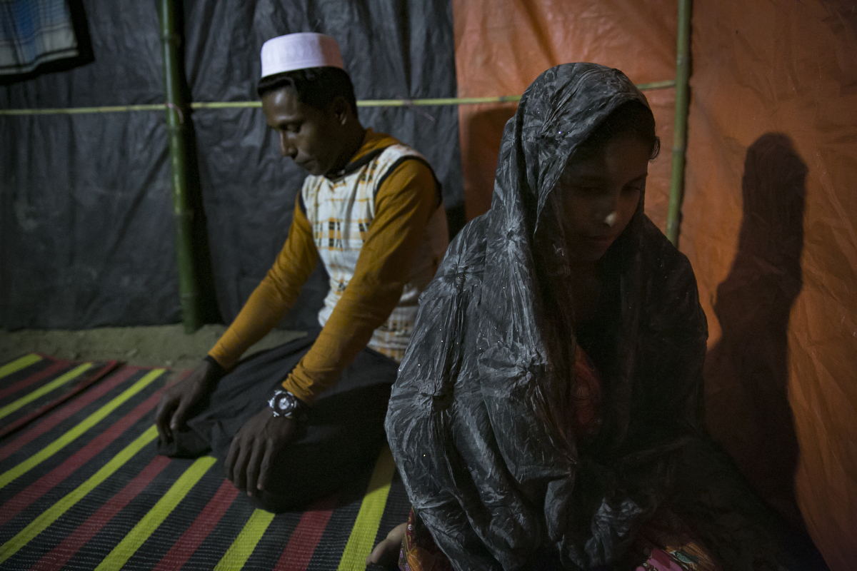 Amina Begum, 15 , sits with her new husband, 22 year old Munir, after their marriage ceremony in a Bangladesh refugee camp in Cox's Bazar, Bangladesh. Her husband, Munir, 22, is from same village. Amina and her family fled their village after the August 25th attack when the army and Buddhists opened fire on the village. They had to walk for 13 days to the Bangladesh border, sleeping in the forest and taking shelter in other villages on the way. Amina's father has 8 children, 5 girls and 3 boys. He says 'I already have a lot of daughters, if I marry them off it's good for me. If I get the opportunity I will marry the rest off as soon as possible. If I die, who will take responsibility for them?' Munir says 'I think 18 is the best age for a girl to get married, but we knew each other in the village so it's okay.' 
