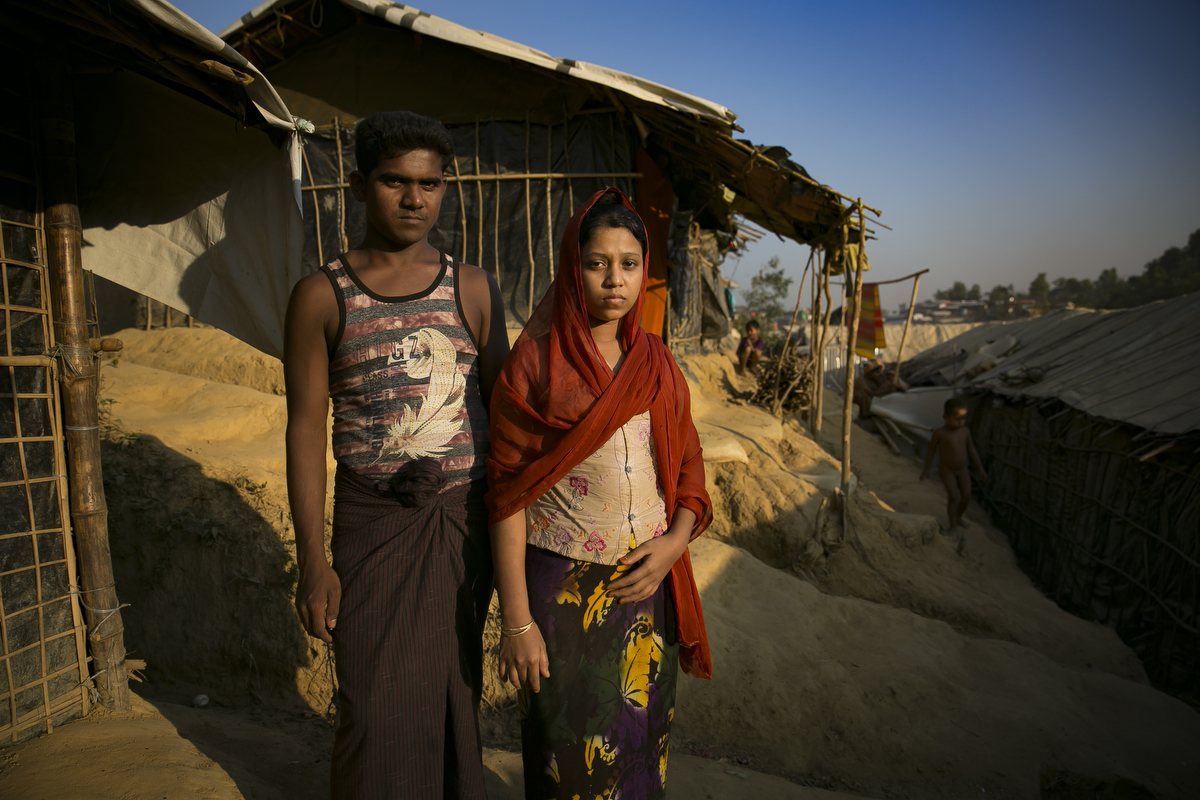 Abdul Karim, 20 and Arifa Begum, 16, pose for a photo in Cox's Bazar, Bangladesh. They were married in a Bangladesh refugee camp one week ago. Arifa fled to Bangladesh from Bouli Bazar in Myanmar and Abdul fled from Tula Toli, both after the August 25th attack. Abdul says 'I didn't want to get married, I wanted to wait until I can go home to Myanmar. I have no work here, how can I support a family? My father wanted me to get married because food ration cards are given to individual families here'. Arifa says, 'I didn't want to get married, but I can't deny my parents wishes. My father wanted me to get married, I don't have a choice. I have to do what he says'. Arifa's father, Abdul Mabub says 'I don't have enough food to feed her. The camp is unsafe and marriage means safety. I'm not home to look after her all the time, now her new family looks after her and she's not my responsibility anymore'. 