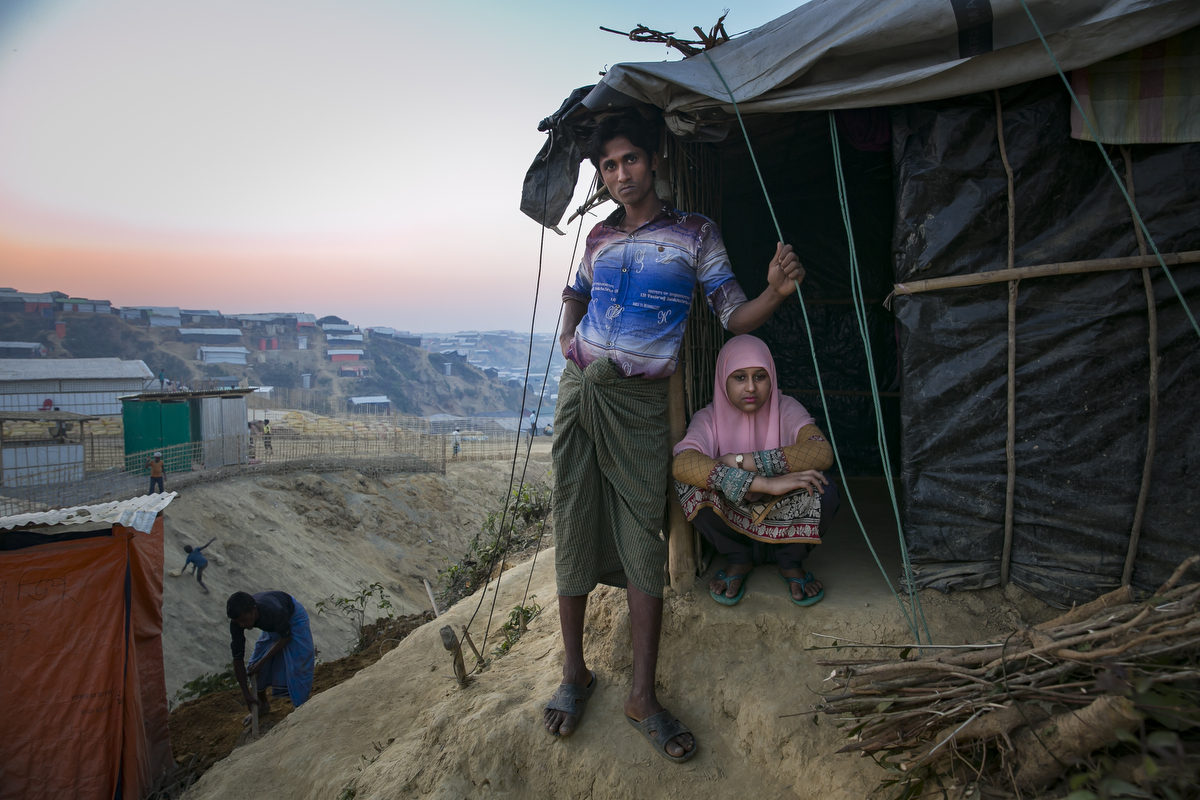 Rahul Amin, 20, and Sabakur Nahar, 15, pose for a photo in Cox's Bazar, Bangladesh. They were married two months ago in a Bangladesh refugee camp. Rahul is from Tula Toli and Sabakur is from Bouli Bazar. They both fled to Bangladesh after the August 25th attack. Rahul lost 20 relatives in the attack and spent days walking to Bangladesh, hiding in the forest and drinking water from the paddy fields along the way. Sabakur saw her father killed by the military and lost 6 relatives during the attack. She got separated from the rest of her family and spent 8 days walking to Bangladesh. Sabakur and Rahul met in Bangladesh at the Kutupalong transit center. He says that he thought she was beautiful so he approached her and they started talking. After 3 days he proposed marriage to her. She told him yes, but that she couldn't marry him until she found her family. Eventually she gave up hope and they were married a few days later. A few weeks after that she located her family in a camp. Rahul says 'Her age didn't matter to me, her body structure isn't young and small, she looks older, so it's okay. In our culture, women who look older have to get married. If other people see her they'll criticize her family, saying your daughter is getting older she needs to get married now. In Islam, any girl who looks older and is seen outside of the house, it's bad for her family. In the Koran, it says that if anyone sees a girl outside of the house, she will be cursed.' Sabakur says 'I wanted to wait until I was 18 to get married, 15 is too young. I agreed because I didn't have my family here. If I was in Myanmar I never would have agreed to get married. I was all alone here, so I agreed.'