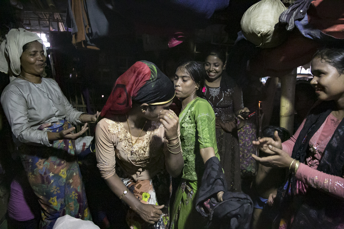 Women dance around Nur Begum (not pictured) who doesn't know her age but thinks she is between 14 and 16 years old, on the day of her wedding to Rayeed Alam, 20, in a Bangladesh refugee camp 