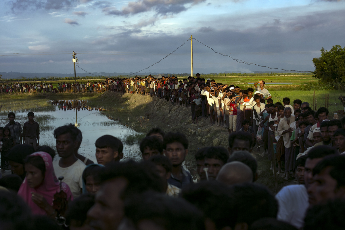  Recently arrived Rohingya refugees wait to receive aid donation