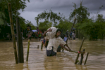 Refugees cross a flooded bridge in the Balukhali Rohingya refugee camp 