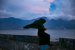 A woman sits on a seawall in Palu, Indonesia.