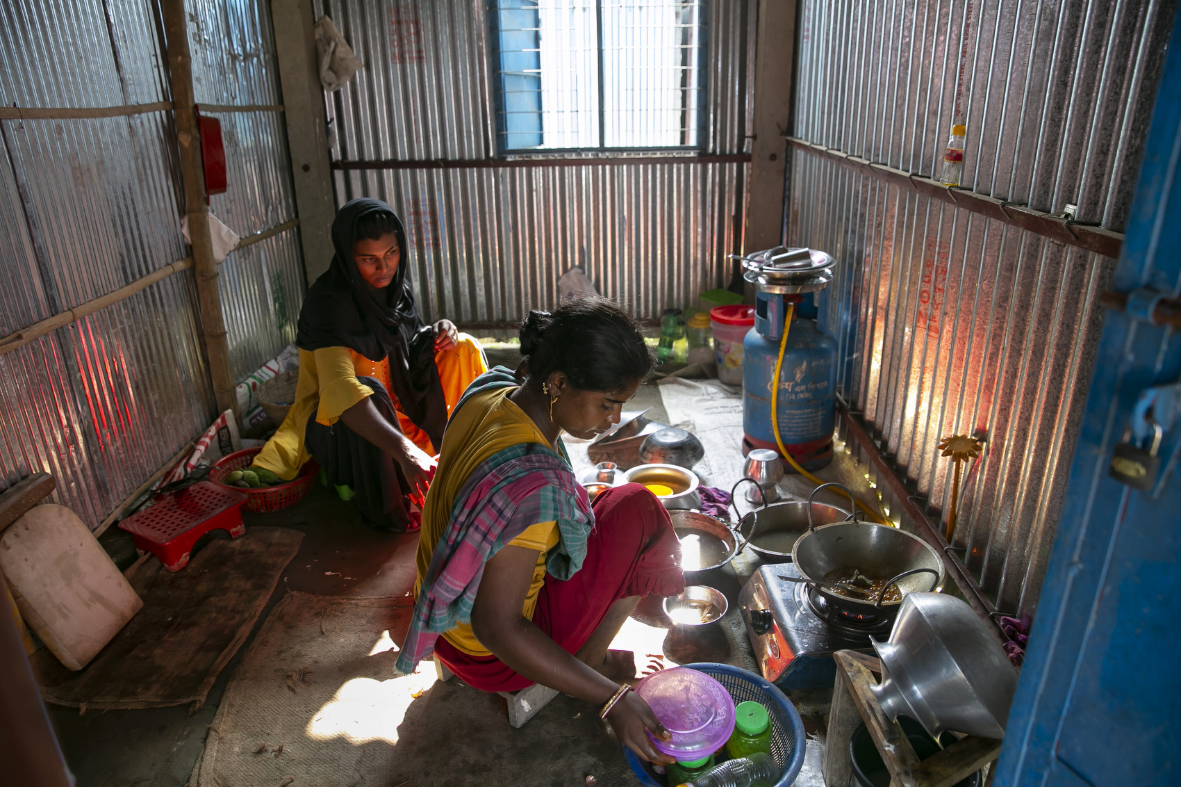 SHERPUR, BANGLADESH - SEPTEMBER 21:  Suravi and Hashi cook breakfast together on September 21, 2021 in Sherpur, Bangladesh. In South Asia, “hijras” are identified as a category of people who are assigned as male at birth but develop a feminine gender identity. They are generally outcasted from mainstream society, and have no other way of earning money other than harassing and extorting people for money. A new government initiative aims to change that. Recently, 40 Hijra were given homes, grants, loans, livestock, and livelihood training in an effort to make them self sufficient. (Photo by Allison Joyce/Getty Images)