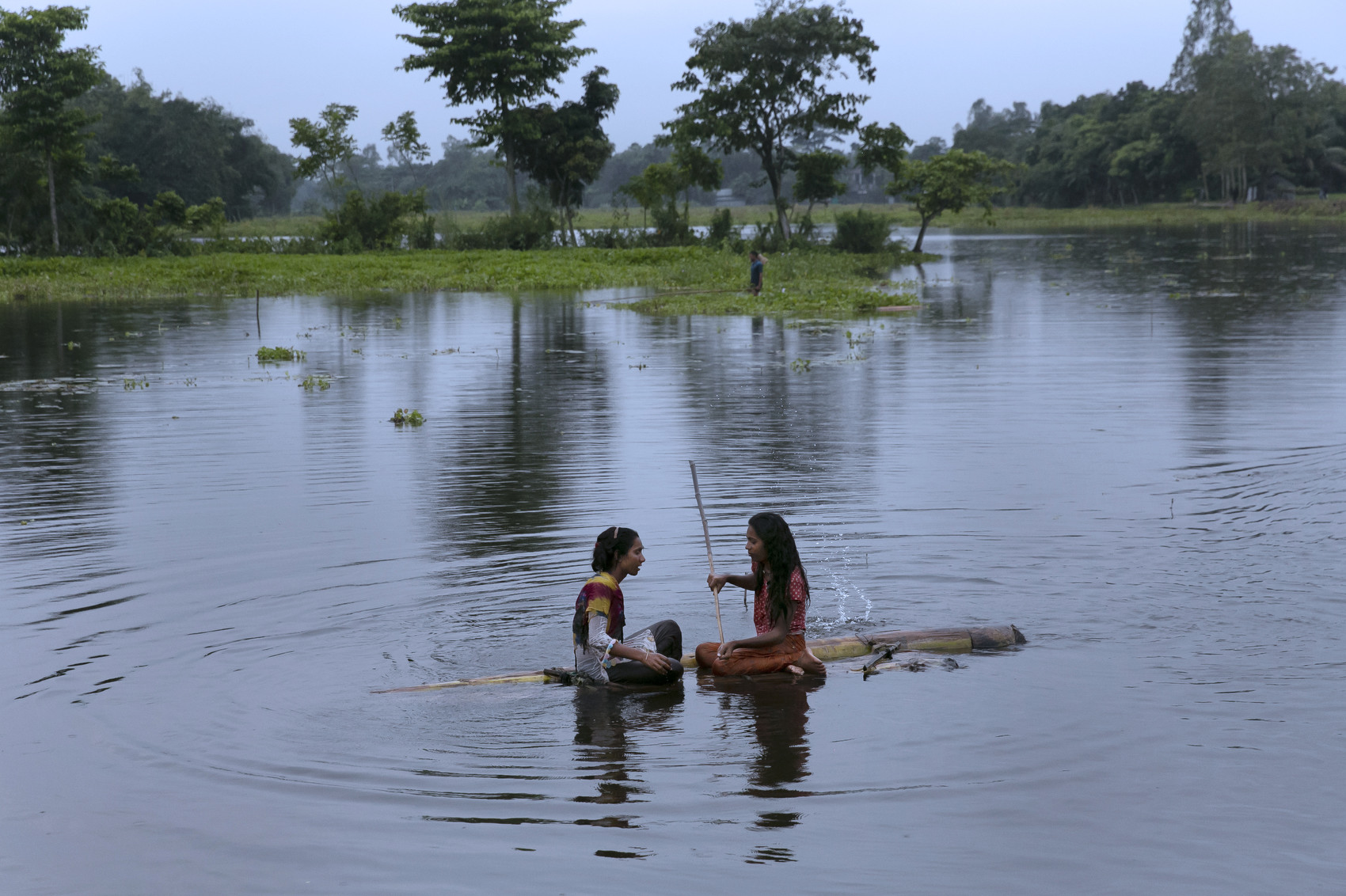 SHERPUR, BANGLADESH - SEPTEMBER 21: Alo and Habiba (L-R) sit on a makeshift boat in a lake by their village on September 21, 2021 in Sherpur, Bangladesh. In South Asia, “hijras” are identified as a category of people who are assigned as male at birth but develop a feminine gender identity. They are generally outcasted from mainstream society, and have no other way of earning money other than harassing and extorting people for money. A new government initiative aims to change that. Recently, 40 Hijra were given homes, grants, loans, livestock, and livelihood training in an effort to make them self sufficient. (Photo by Allison Joyce/Getty Images)