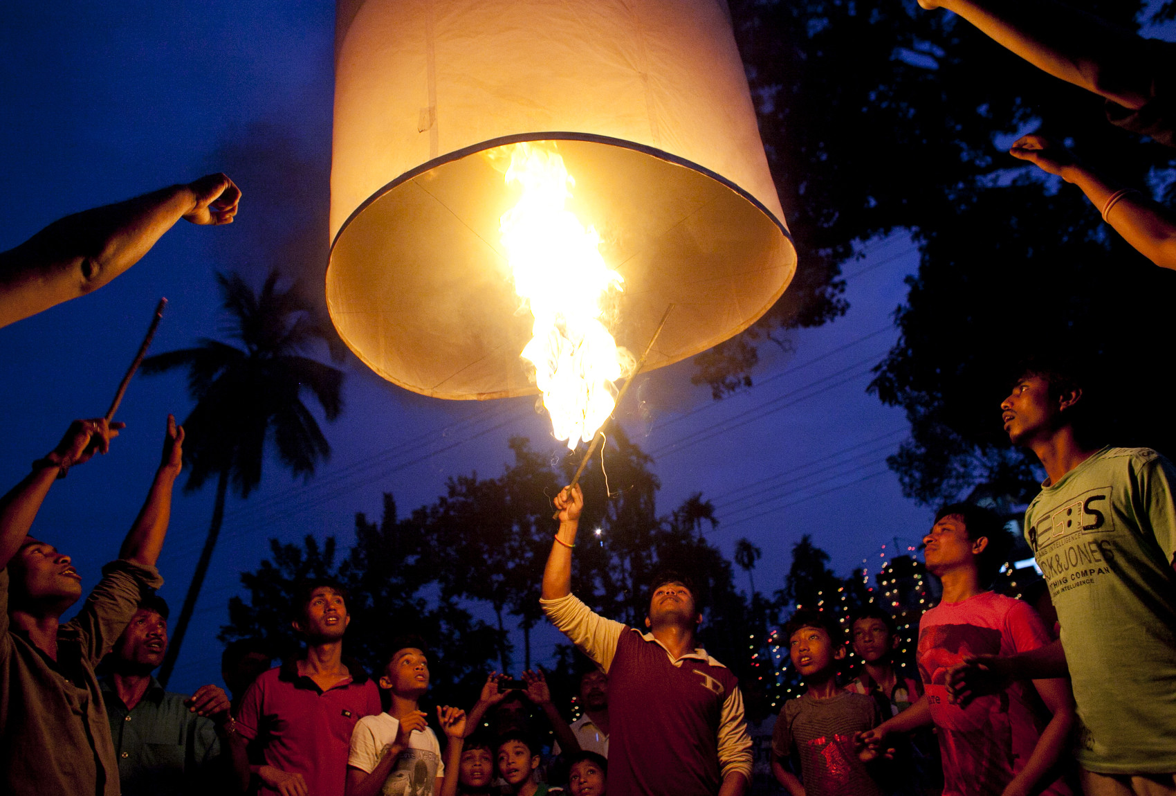 Bangladeshi Buddhists light a large paper balloon into the sky during Probarona Purnima in Ramu, Bangladesh. The Probarona Purnima festival celebrates the conclusion of the three-month long seclusion of the monks inside their monasteries for self-edification. Last year, on September 29th 2012 a muslim mob attacked and destroyed temples and homes of Buddhists after an anonymous person posted a photograph of a desecrated Quran on a local Buddhist boy's facebook wall. The community did not participate in Probarona Purnima last year in protest of the attacks. 
