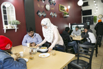 Rohingya refugee Naznin serves food at her mother's restaurant, the Tea Leaf Garden restaurant on January 11, 2019 in Chicago, Illinois. In 2018 Rohingya refugee Nasimah and her friend opened the Tea Leaf Garden restaurant, which serves halal Rohingya, Malaysian and Burmese food. Nasimah escaped violence and oppression in Myanmar in 1977 to Malaysia and was resettled with her family in Chicago in 2012. Her son Mohammad says that {quote}Everything is better here in the US. We are able to go to school.{quote}