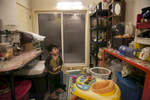 2 year old Amirul watches TV on a phone while his mother cooks dinner on January 12, 2019 in Chicago, Illinois. The Shukor family arrived in Chicago in 2014 from Malaysia. Mohammad Shukor fled Myanmar in 1978 after the military shot him and arrested his father, who died in jail. He fled to Thailand by boat and spent 5 years there before making his way to Malaysia with his family. In Malaysia he and his family were denied an education, had to work illegally, and were frequently arrested and harassed by authorities. When he and his family were resettled in the US he says he {quote}felt so happy to finally have a country, to finally have a place to call home{quote}. 