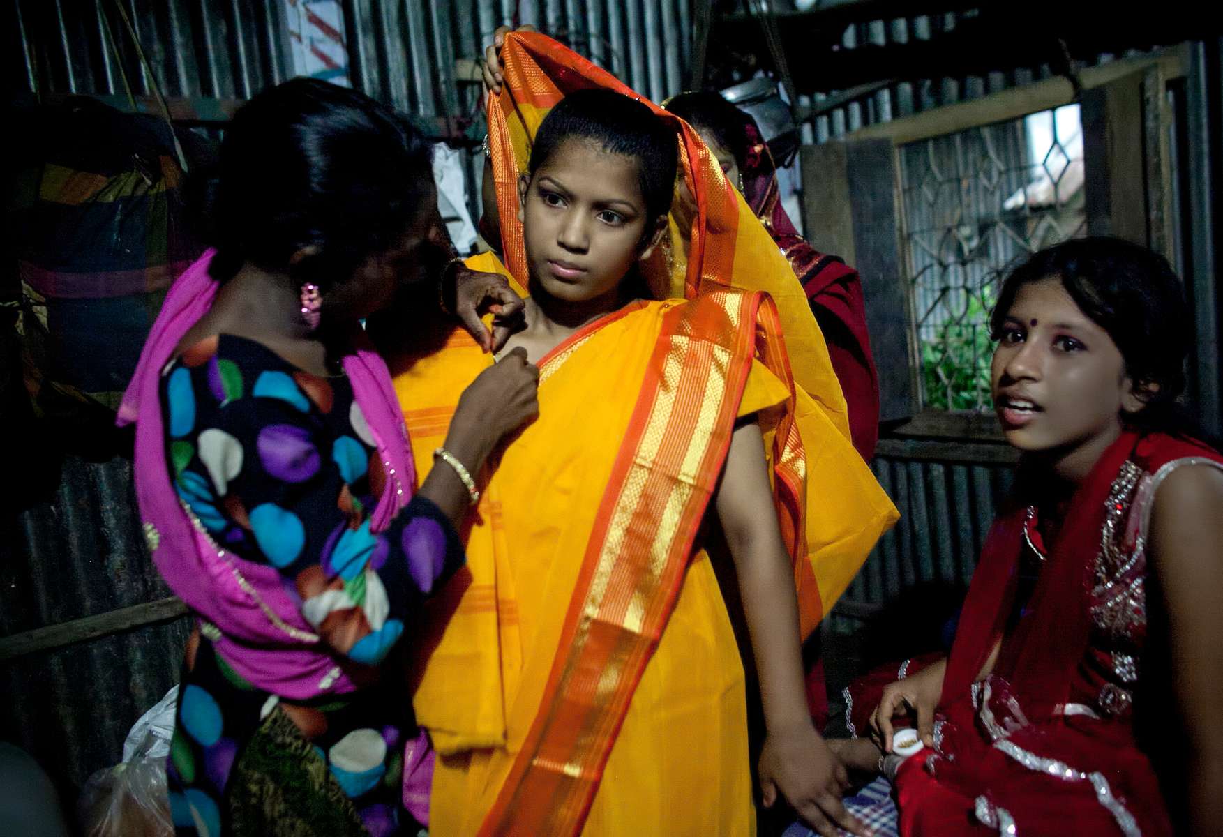 13 year old Runa Akhter is dressed for her holud ceremony the night before her wedding to a 29 year old man in Manikganj, Bangladesh. Runa was in the 7th grade, and loved reading, sports and traveling. She wanted to wait until she was 21 to get married but, {quote}No boy want's to marry a girl older than 18 in my village{quote} she said. 