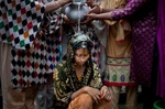15 year old Nasoin Akhter is bathed on the day of her wedding to a 32 year old man in Manikganj, Bangladesh.