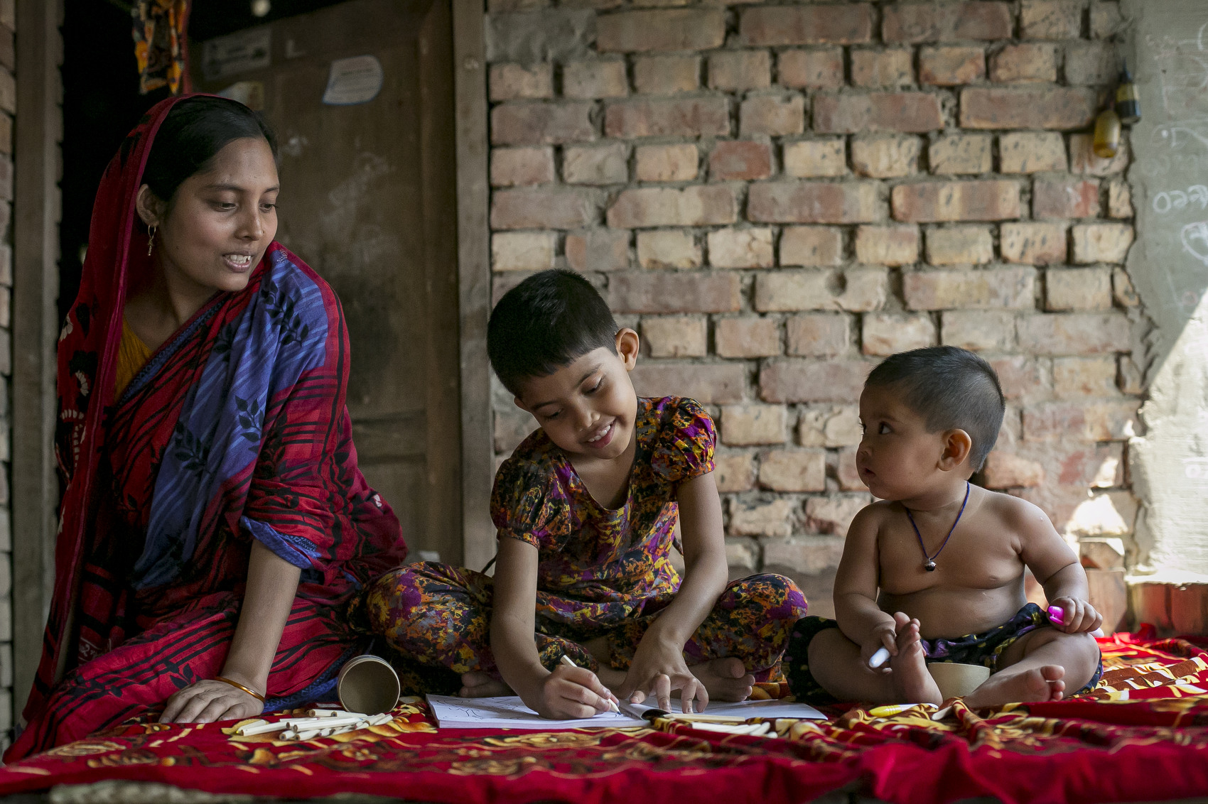 Mosamad Muslima Khatum plays with her baby sister while her mother XXX looks on at her home in Govindapur, Satkhira March 4, 2017 in Khulna division, Bangladesh. © Sightsavers/Allison Joyce 