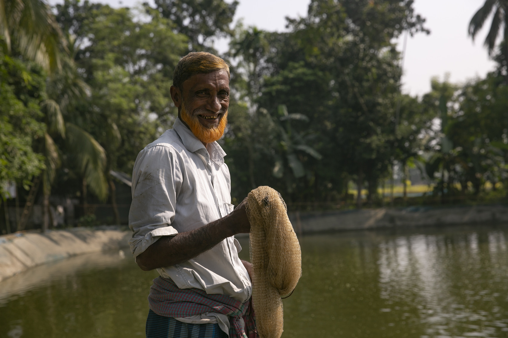 Rusmot Ali works on their fish farm in Mymensingh, Bangladesh