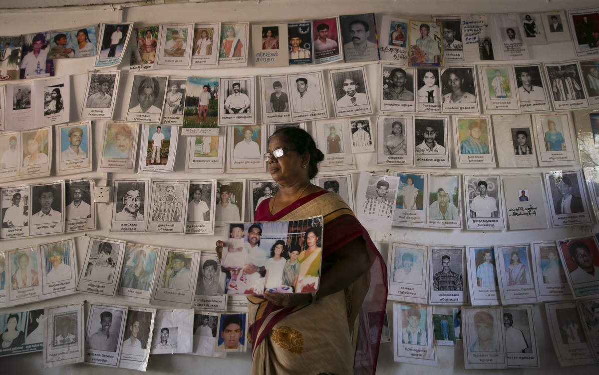 Thangavel Sathiyathek holds a photo of her son, Magalingam Sivagini and his family at a protest site for loved ones of the disappeared in Mullaitivu, Sri Lanka. Thangavel Sathiyathek is missing her son, Magalingam Sivagini and his family. On the 18 May 2009 it was ordered that all LTTE should surrender. Thangavel went with her son and his family to the military camp to surrender. The military took him, his wife and their 3 children and she hasn't heard from them since. When she went to inquire about them at a military camp 3 days later she was arrested and held for 1 month. A few years ago she paid 400,000 rupees to someone who called her and promised if she paid money he would be released, but he never was. Sivagini was a politician in LTTE and his wife worked as a lawyer in the LTTE courts. {quote}I understand why they might want to hold adults by why would they keep the children? The youngest was only 2 1/2 years old. It's been 10 years, why are they keeping them? The government says everything is safe here in Sri Lanka and there are no problems, why can't they release them? Why would they keep them?{quote} Thangavel says.