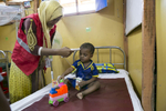 Anwar plays during a checkup at the PHCC October 1, 2018 in the Rohingya refugee camp in Cox's Bazar, Bangladesh. Anwar (22 months) is a Rohingya refugee who lives with his mother Rahima and father Mohammed Amin, brother and sister in the Rohingya refugee camps in Cox’s Bazar, Bangladesh. In June 2018, Anwar was admitted to the Save the Children Primary Health Care Centre (PHCC) suffering from symptoms of pneumonia. After three days of treatment, where he received care from Save the Children’s doctors and paramedics, Anwar was discharged from the PHCC. Rahima and Mohammed said that in Myanmar it would take a whole day to get to a hospital, so they didn’t go very often. They are now happy and feel good that they have a good health care centre located close to their home in the camps. They said they want to think Save the Children for all their help, and that if they return to Myanmar they will never forget the help they have received from Save the Children. They said that they would recommend all their friends and neighbours to come to the PHCC because the treatment is good, and there are doctors and nurses. 