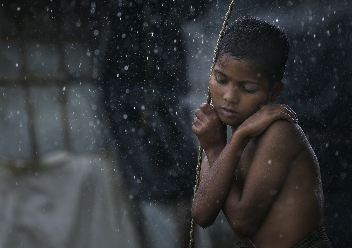 Rohingya are seen during a rainstorm at Nayapara refugee camp 