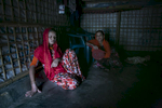 NurNahar Begum  and Yasmin are seen in their shelter. Yasmin Akhter, is a 14 year old wife and mother. She came to Bangladesh when she was 8 years old. She never had the chance to go to school. Her father left the family and left her mother, 40 old NurNahar Begum, and two years after she fled from Myanmar to Bangladesh she was sent to Chittagong to work as a housekeeper for a family of 5. She worked there for two years, never receiving a formal salary, getting only 200 or 300 taka occasionally. The mother that she worked for beat her frequently. She wasn't allowed to go outside, but Yasmin stayed thinking that it was the only way she could help her family.  One day she couldn't take any more and she called her mother and told her about the abuse, and said if she stayed there one more day she would die. Her mother brought her back to the refugee camp and arranged for her to get married. Yasmin was 12 years old when she married her 30 year old husband. When Yasmin was married she was happy, she thought that her husband would provide a better life for her, but he is sick and unable to work, and their food rations from the NGOs are not enough. 9 months ago Yasmin gave birth to a baby girl. She dreams of a better life for her daughter, one where she is independent, educated, and works a respected job. {quote}It will be up to her when she gets married{quote} Yasmin says. NurNahar Begum says {quote}I didn't have any choice, that's why I had to make this decision. I took two wrong decisions for her life. The first one sending her to Chittagong to work as a maid and the second one in getting her married. I didn't know it would turn out like this. I always tried to give my kids a good life but I failed. We never had enough food, no good shelter, they were never able to get an education. I failed.{quote}