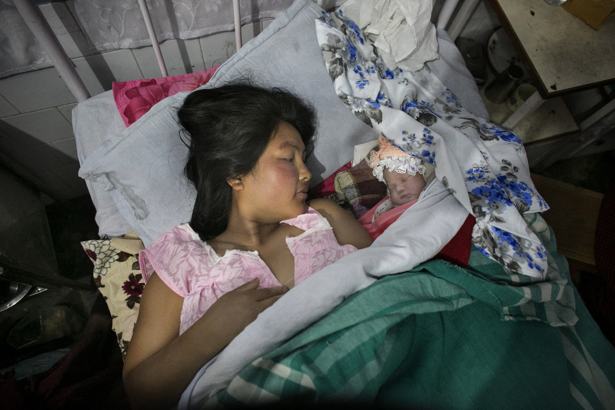 Enora Warmalai lays next to her newborn daughter in the maternity ward of a hospital
