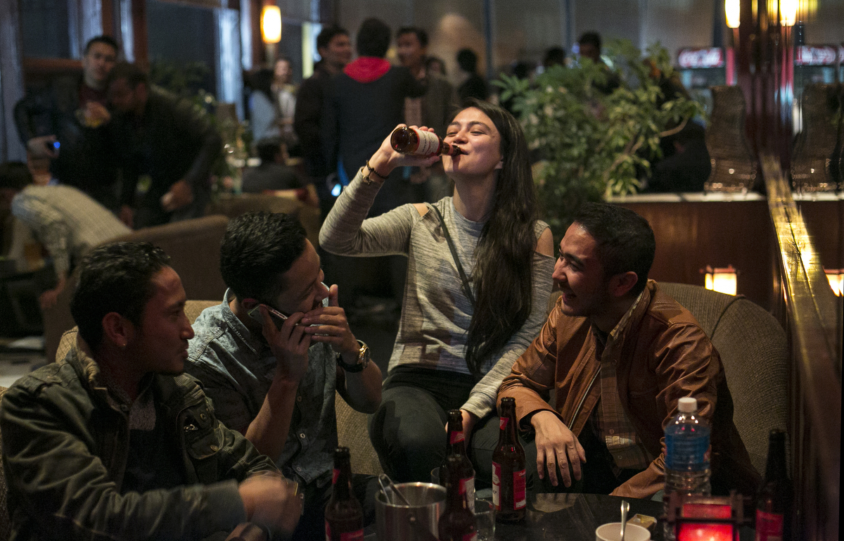 Men and women enjoy a night out at a bar in Shillong