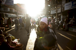 A woman shops with a baby on her back at a market in Shillong