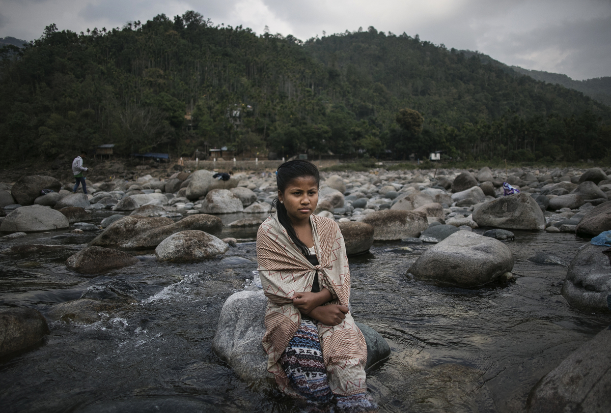 A girl sits on a rock in Shnongpdeng Village
