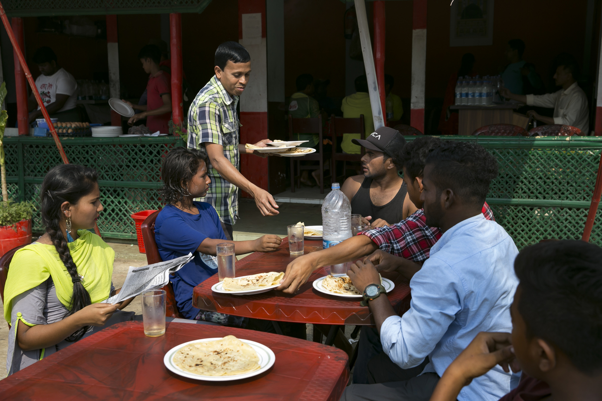 Sumi, Aisha, Rashed and other surf club members eat breakfast 