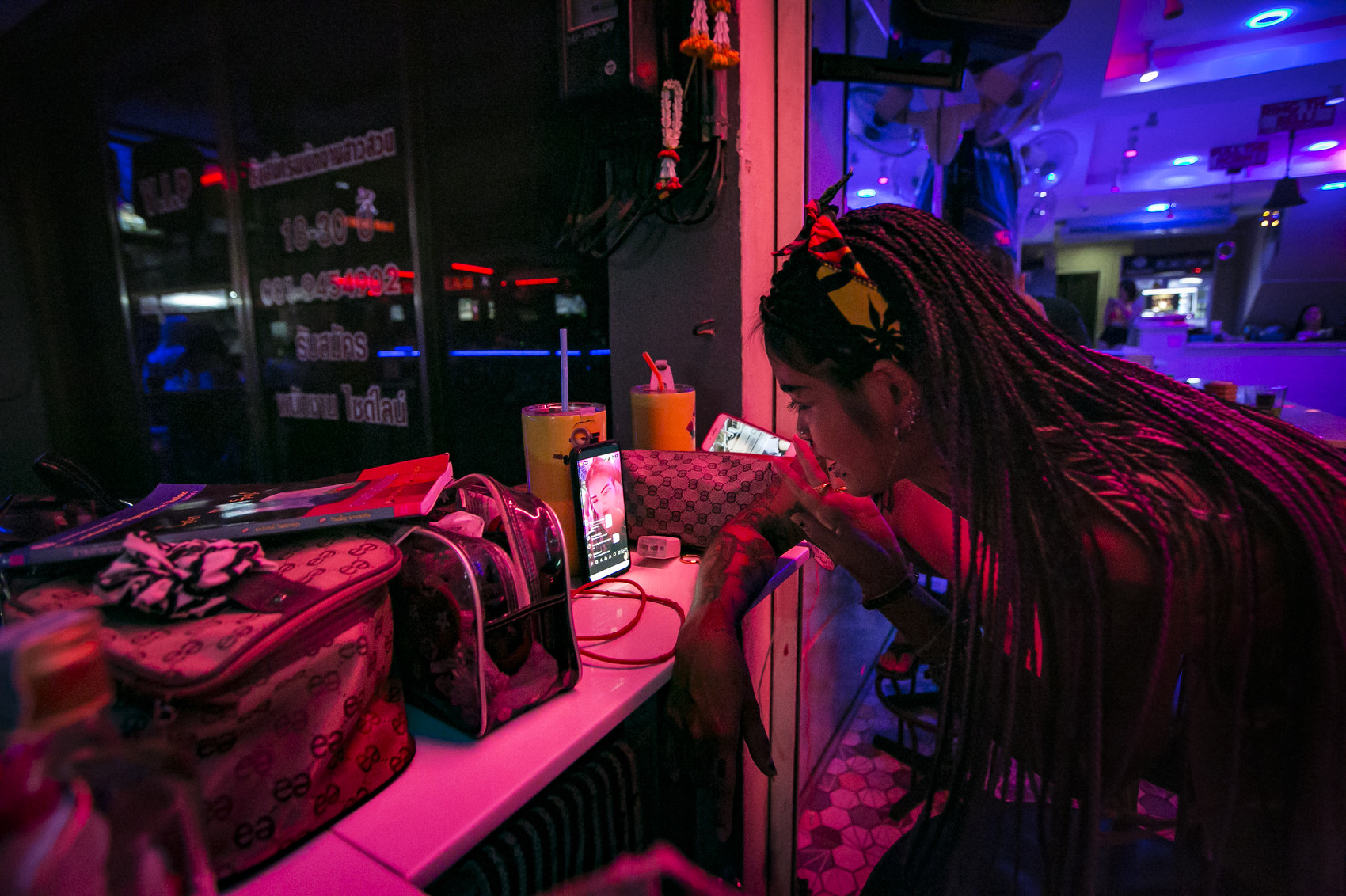Nim goes live online at her bar  in a red light district in Pattaya , Thailand, September 12, 2020. As customers are relatively scare now, some sex workers have moved their services online, with livestreams over social media. The women will dance in front of the camera, enticing men to buy them a shot or send money over PayPal.With entry into Thailand still restricted, and relatively few tourists able to enter, a good living has turned into a bad one for the country's sex workers.