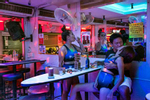 Girls entertain a customer in a red light district in Pattaya , Thailand
