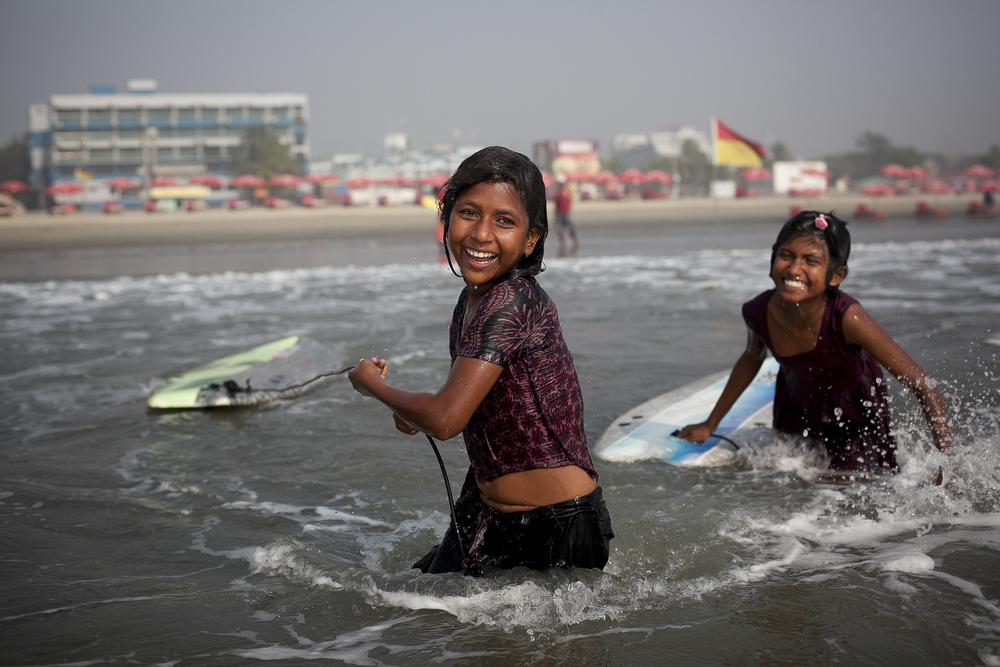 Aisha and Johanara laugh while surfing