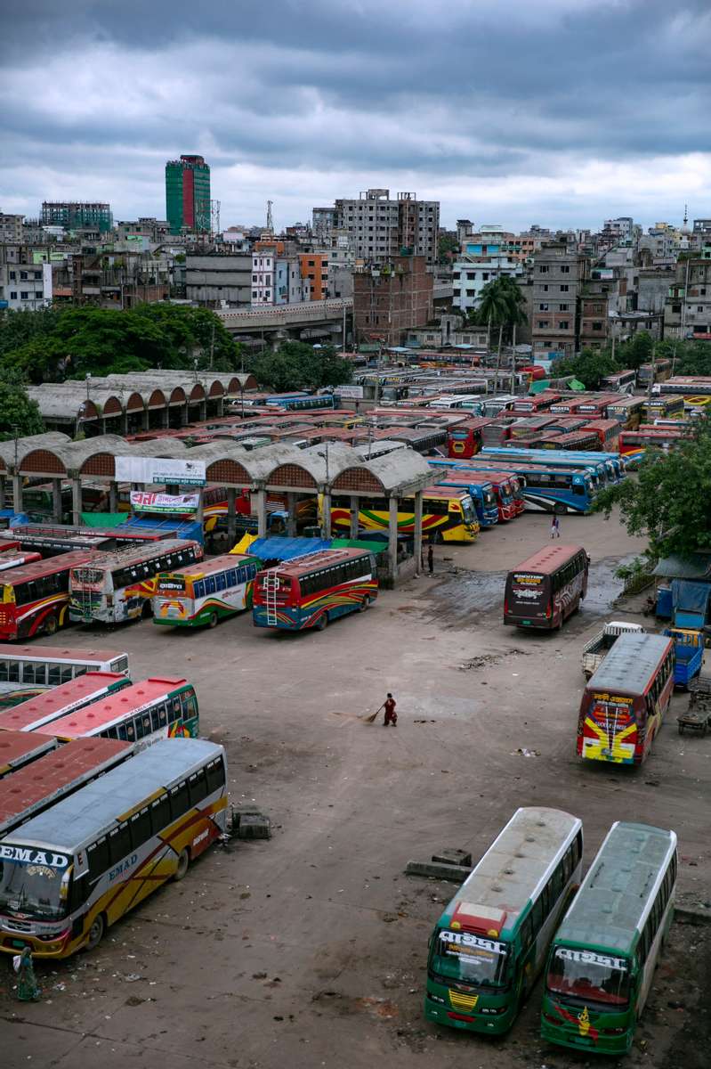 A woman sweeps at a bus depot is seen on the first day of a renewed nationwide lockdown in Dhaka, Bangladesh.