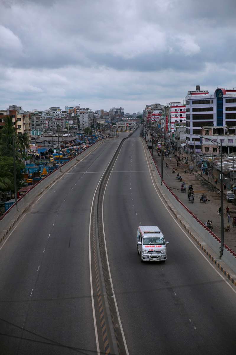 An ambulance drives down an empty road on the first day of a renewed nationwide lockdown in Dhaka, Bangladesh.