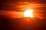 A partial solar eclipse is seen setting behind the Blue Ridge Mountains from a vantage point on Candler\'s Mountain Thursday evening, Oct. 23, 2014  in Lynchburg, Va.
