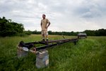 Robert Schumacher pauses for a moment as he stands on a trailer during a cook out for members of the batteau community in and around Lynchburg. Around 50 people came together to flip the Lizzie Langley over and load her onto a trailer for transportation to the James River.