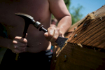 Dan Tucker fills small holes in the batteau's hull with oakum, a fibrous caulking substance. 