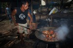 Bang Dii uses a large wok and wood fire to cook the days crab catch. The cooked crab will be taken to a neighbor’s home to sort and process for sale.