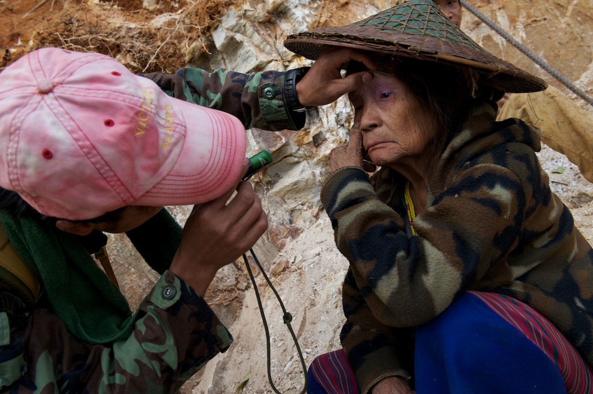 Silver Horn, a member of the Free Burma Rangers examines a women's eye for cataracts. 