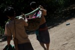 Villagers use a bamboo hammock stretcher to carry a young girl who has a severe case of staff infection to the JSMK clinic two hours away. This patient was diagnosed with a severe case of staff infection in her left shoulder and left hip, a life threatening infection that was succesfully operated on. 