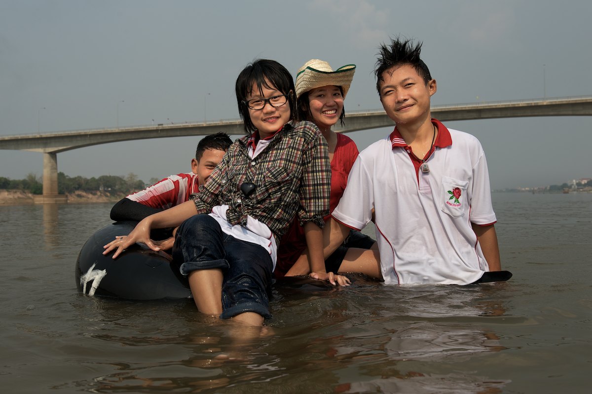A group of young Thai teenagers cool off and enjoy their weekend swimming in the Mekong River near the Thailand-Laos Friendship Bridge. 