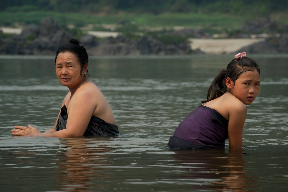A Laotian mother and daughter take an afternoon bath in the Mekong River.