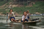 A group of children paddle to school on the confluence of the Nam Ou and Mekong rivers, near Pak Ou, Laos. 