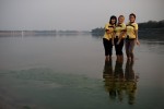 Three colleagues take a short evening break from work in Vientiane to cool off by the Mekong River and watch the sunset. 