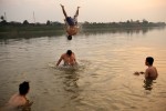 At the end of the day a group of young men swim and cool off in the Mekong River. 
