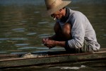 A fisherman checks and cleans his net near the proposed site of Pak Chom dam along the main course of the Mekong River.